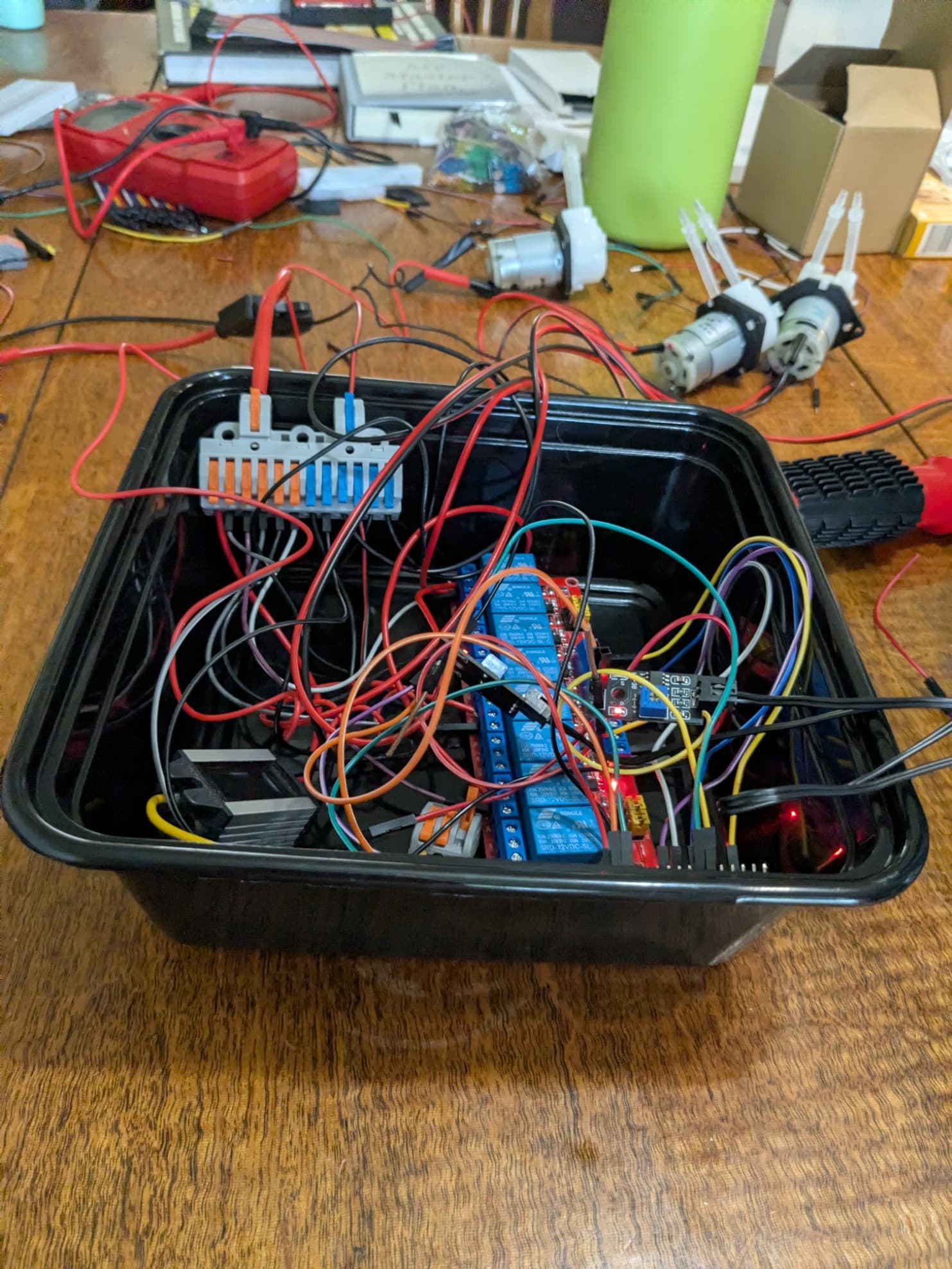 Tupperware containing ESP-32, buck converter, wire splitter, fuse, relay
